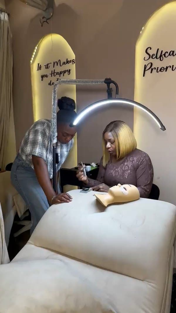 A one-on-one demonstration with lash tools and a training mannequin.